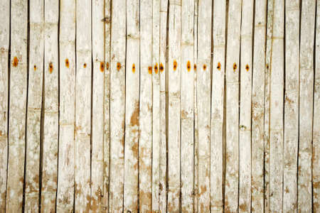 The texture of a wall of bamboo, with rusty old nails.の写真素材