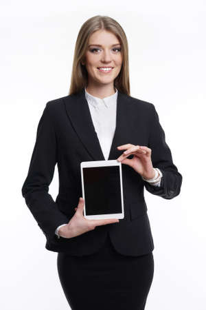 Business woman holding a tablet computer to take . European appearance. On a white background in a business suit .の写真素材