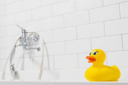 Close-up Yellow duckling toys in the bathroom on a background of shower and brick tiles.の写真素材