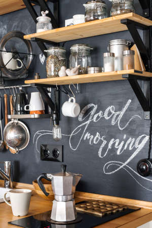 Design of modern kitchen in loft and rustic style. Geyser aluminum coffee maker on the background of a black wall with the chalkの写真素材