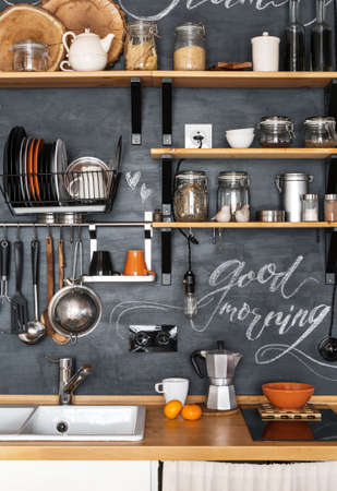 Design of modern kitchen in loft and rustic style. Wooden Shelves with different jars on a black wall with chalkの写真素材