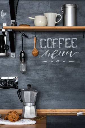 Inscription Inscription Inscription "Coffee Menu" with chalk on a black wall Kitchens in the style of Loft and Rustic. Geyser coffee maker, wooden shelf, cookies.の写真素材