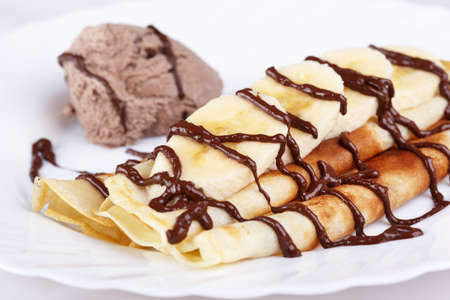 Thin pancakes with banana, ice cream and chocolateの写真素材