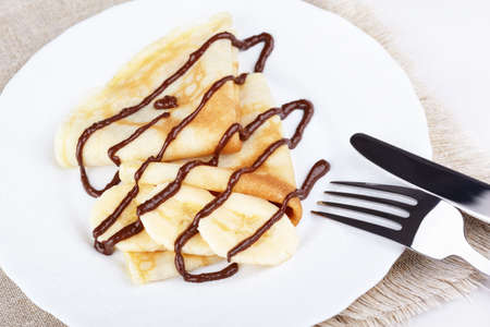 Thin pancakes with banana and chocolateの写真素材