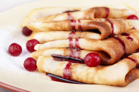 Pancakes with cranberry berries and jam on a plateの写真素材