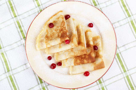 Pancakes with cranberry berries on a plateの写真素材