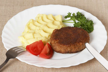 Cutlet with mashed potatoes and vegetables on white plate