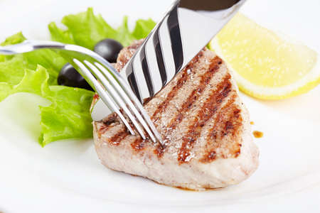 Grilled steak on white plate closeupの写真素材