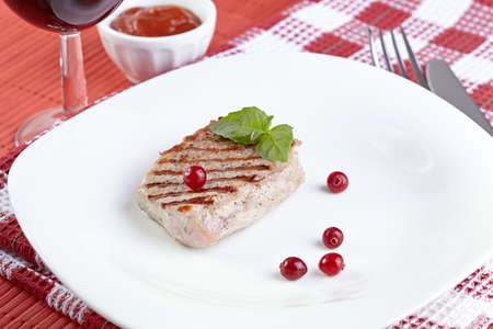 Grilled steak with a cranberry on white plateの写真素材