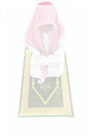 Arabic Muslim woman praying on the carpet isolated on white background.の写真素材