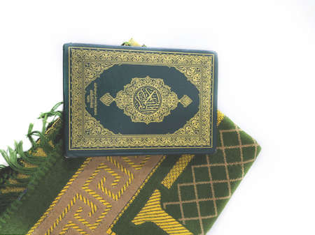 Photos of the Koran and prayer rugs ready for Ramadan.  Arabic on the cover is translated as the Qur'anの写真素材