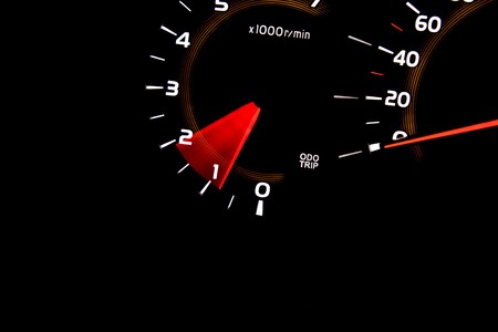 Car dashboard gauges illuminated at night, tachometer, speedometer