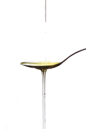 Olive oil poured  into a spoon の写真素材