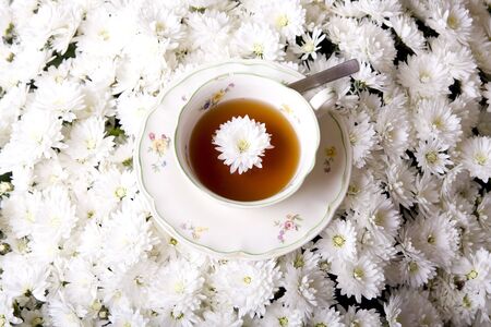 Cup of tea in flowers surroundingの写真素材