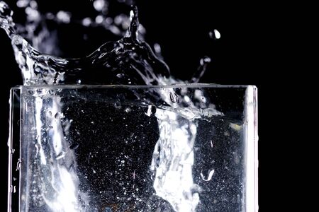 Water drops flow into glassの写真素材