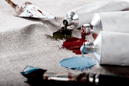 Paint tubes on linen canvas の写真素材