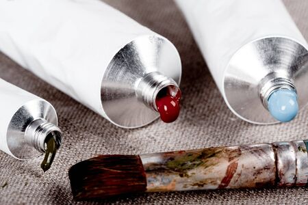 Paint tubes on linen canvas の写真素材