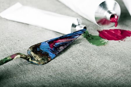 Paint tubes on linen canvas の写真素材