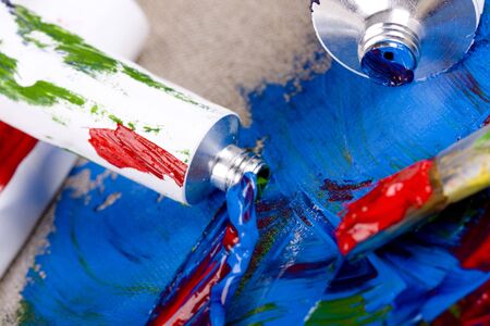 Paint tubes on linen canvasの写真素材