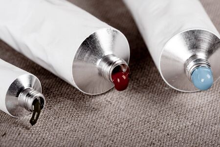 Paint tubes on linen canvas の写真素材