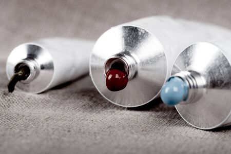 Paint tubes on linen canvas の写真素材