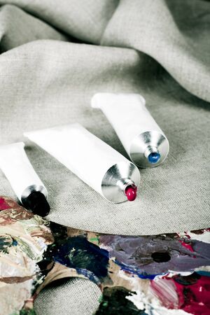 Paint tubes on linen canvas の写真素材