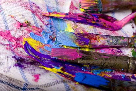 Artistic equipment: paint, brushes and knives on paint backgroundの写真素材