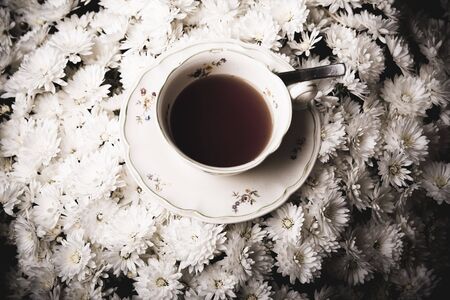 Cup of tea in flowers surroundingの写真素材