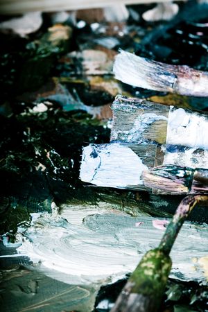 Artistic equipment: paint, brushes and knives on paint backgroundの写真素材