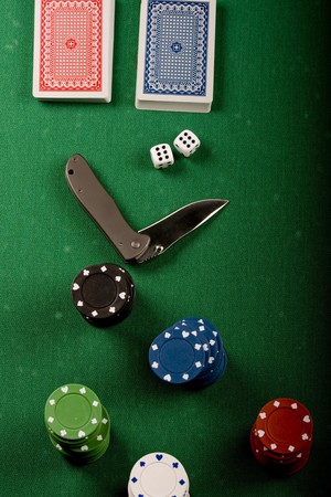  Casino gambling chips, cards and knife  on green tableのeditorial素材