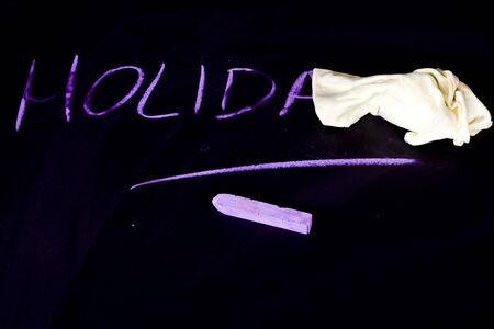 Holidays written on black chalkboardの写真素材