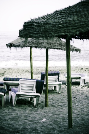 Straw umbrella on the beach and chairs