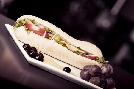 long baguette sandwich with cheese,  fresh vegetables and olivesの写真素材