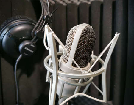 microphone and headphones in the sound studio against the background of soundproofing panelsの写真素材