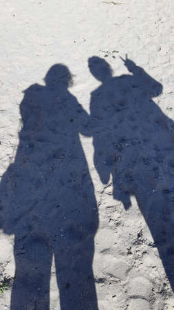 shadows of two people on the roadの写真素材