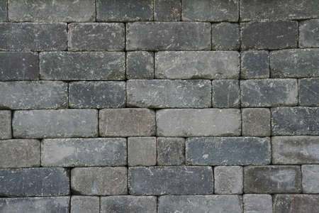 Different shades of grey bricks making up a wall.の写真素材