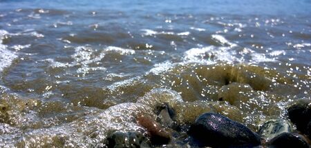 Little wave splashing on pebblesの写真素材