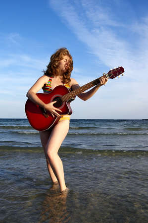 women, guitar and seaの写真素材
