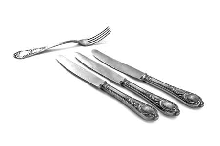 three table knifes and fork on white backgroundの写真素材
