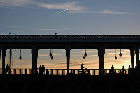 Sunset colors through the famous Bir Hakeim bridge in Paris with silhouettes