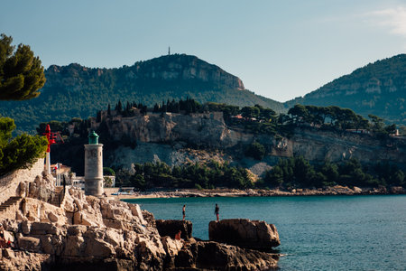 People enjoying a sunbath on the rocks in the village of Cassis in South of Franceの写真素材