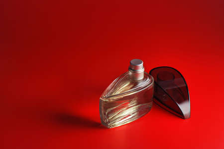 perfume. A bottle perfume on a red background with effective illuminationの写真素材