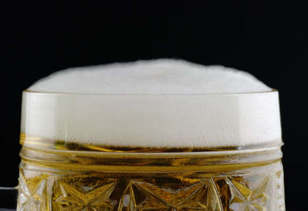 Glass of beer. A close-up shot of the foamed beerの写真素材
