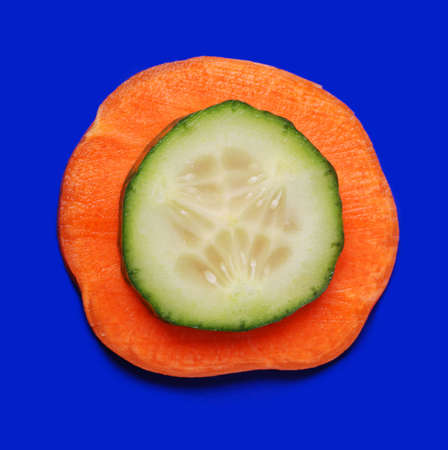 Carrots and cucumber on a dark blue background. Bright paints of a fresh productの写真素材