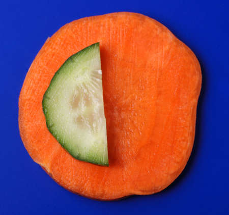 Carrots and cucumber on a dark blue background. Bright paints of a fresh productの写真素材