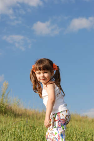 The girl on a field. The cheerful child on a years meadowの写真素材