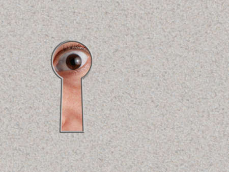 Look through a keyhole. An eye - peeping through a crack.の写真素材