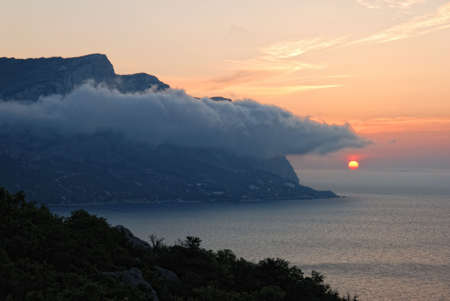 Sunset. A picturesque sunset with fantastic foggy under mountainの写真素材