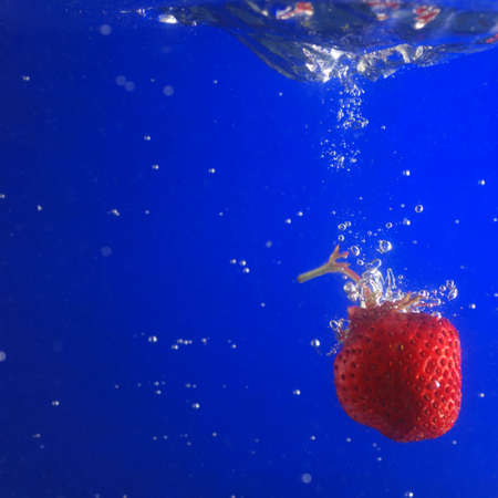 Strawberry in water. A falling berry in cold water.の写真素材
