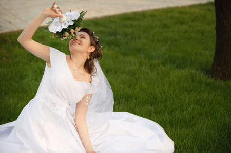 The bride on a lawn. The young girl in a wedding dress.の写真素材